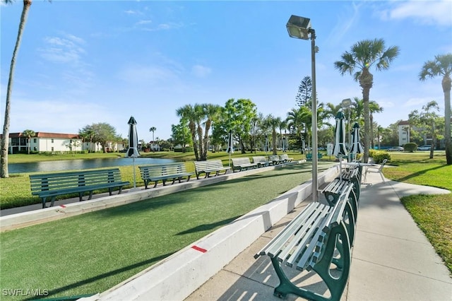 view of community with a lawn and a water view