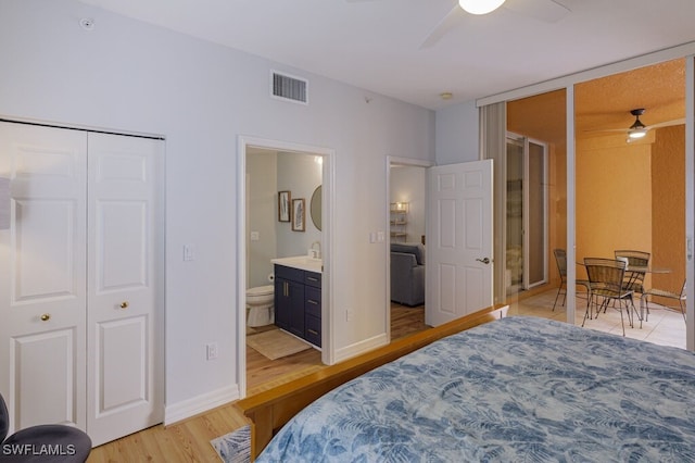 bedroom with ceiling fan, ensuite bath, and light hardwood / wood-style floors