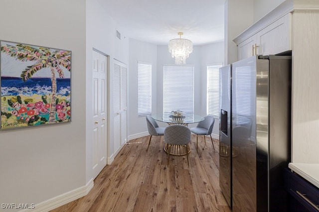 dining room with an inviting chandelier and light hardwood / wood-style floors