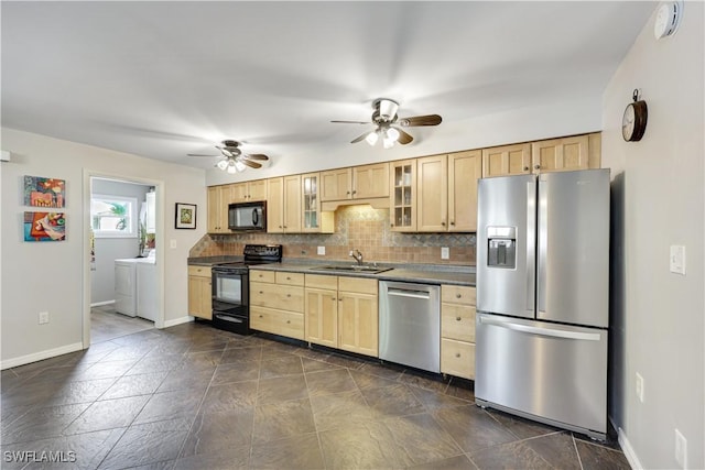 kitchen featuring tasteful backsplash, washer and clothes dryer, dark countertops, glass insert cabinets, and black appliances