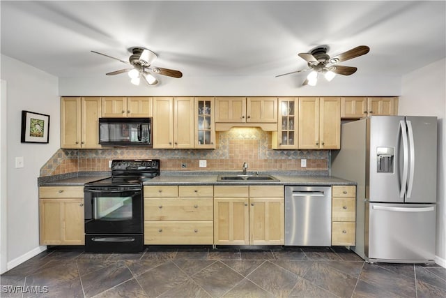 kitchen featuring dark countertops, glass insert cabinets, light brown cabinetry, black appliances, and a sink