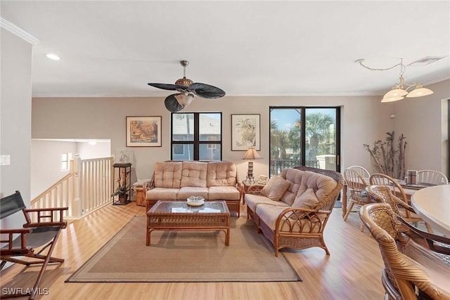 living room featuring crown molding, light hardwood / wood-style floors, and ceiling fan