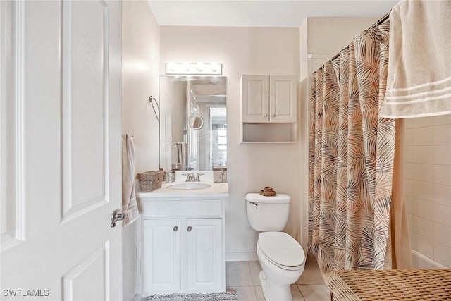 bathroom featuring walk in shower, vanity, toilet, and tile patterned flooring