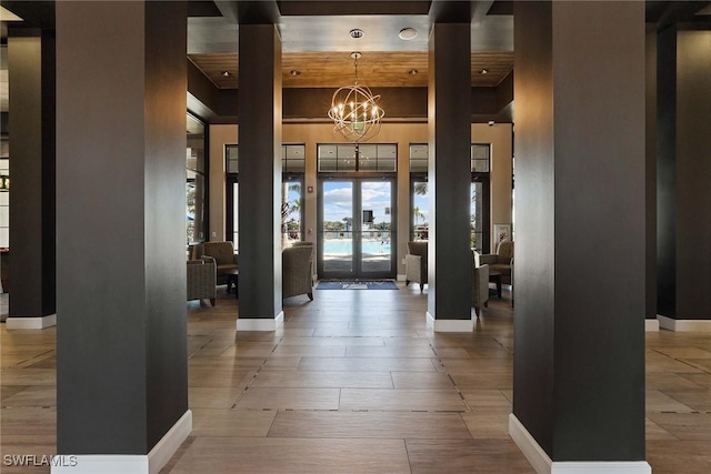 foyer featuring a high ceiling, a notable chandelier, and french doors