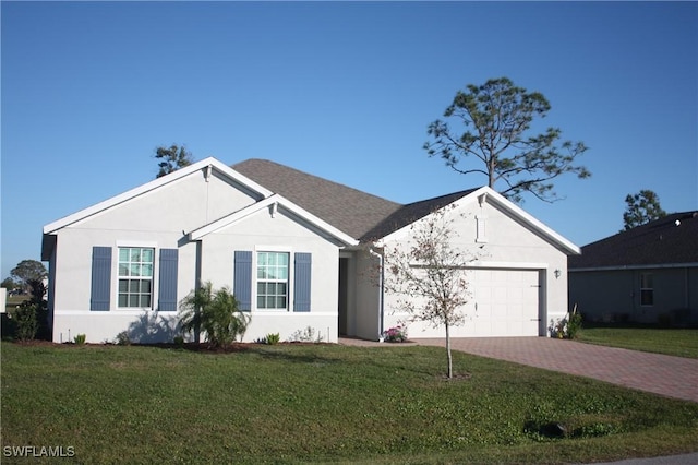 single story home with decorative driveway, a front yard, and stucco siding