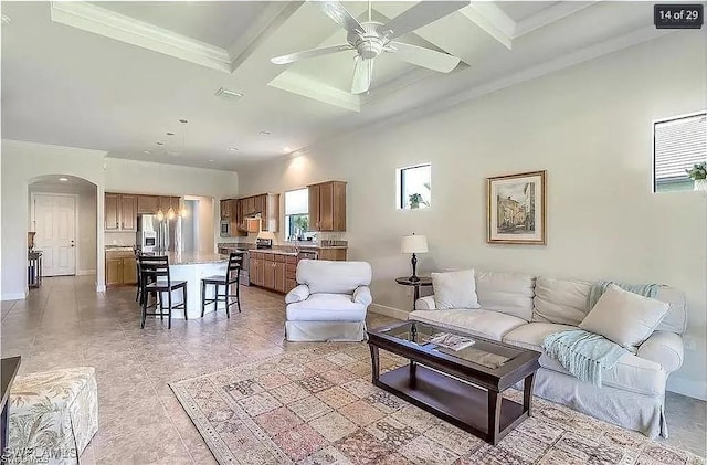 tiled living room featuring ceiling fan, crown molding, beamed ceiling, and coffered ceiling