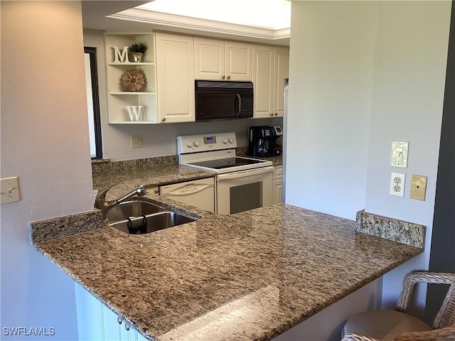 kitchen with white appliances, a breakfast bar, kitchen peninsula, and sink