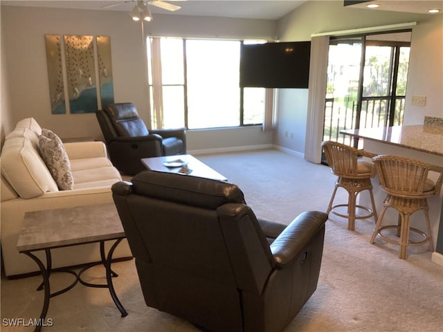 carpeted living room featuring ceiling fan and a healthy amount of sunlight