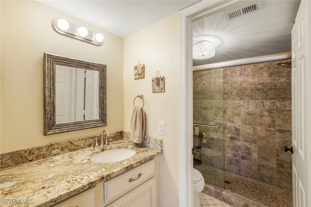 bathroom featuring vanity, a shower with door, and toilet