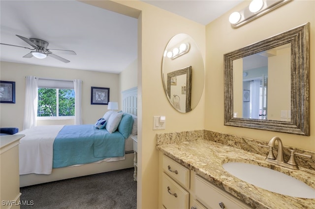 bedroom with dark colored carpet, sink, and ceiling fan