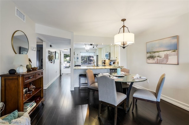 dining space with an inviting chandelier and dark hardwood / wood-style floors