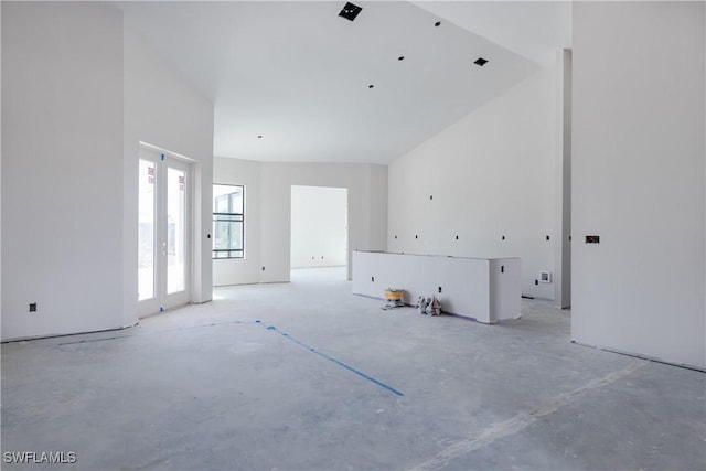 unfurnished living room featuring a high ceiling