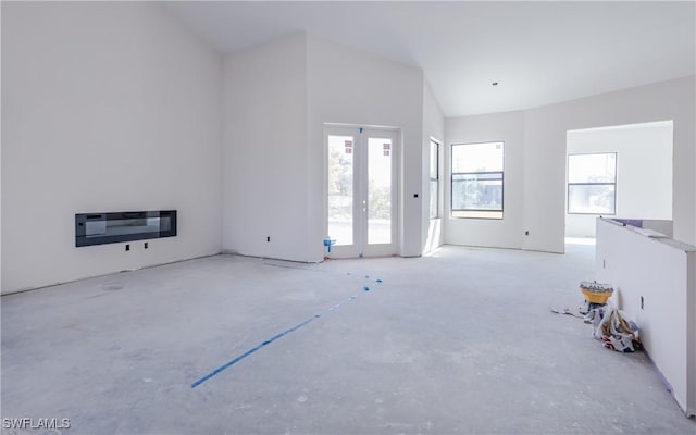 unfurnished living room with heating unit and high vaulted ceiling