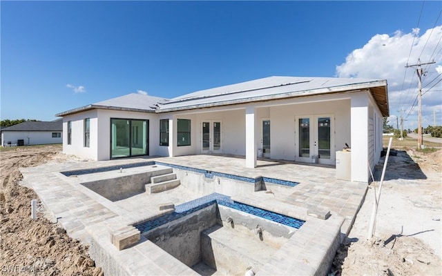 back of property featuring a patio area, french doors, and a hot tub