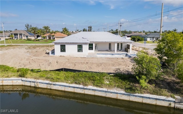 back of property featuring a water view and a patio area