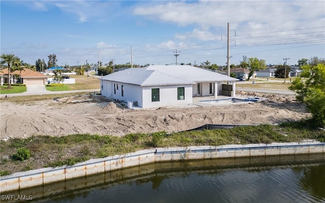 rear view of house featuring a water view and a patio area