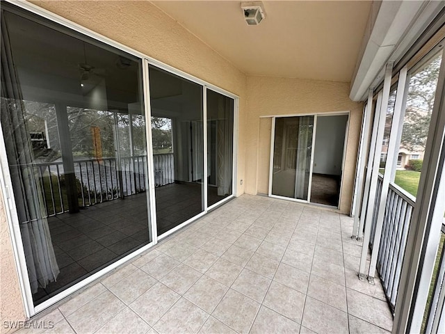 unfurnished sunroom featuring plenty of natural light and vaulted ceiling