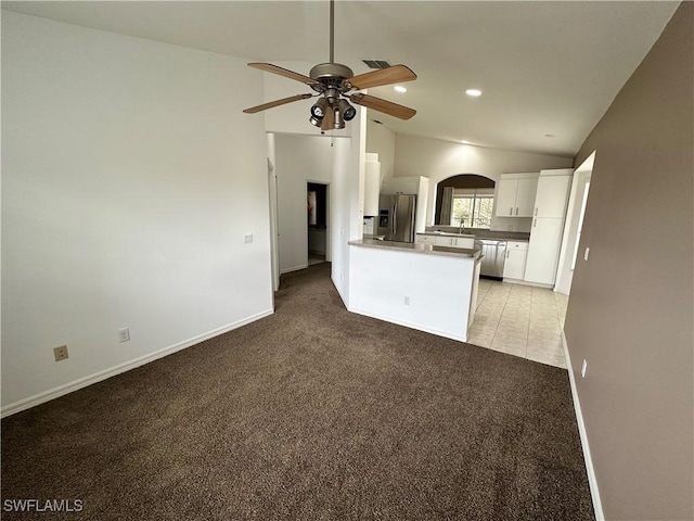 kitchen with ceiling fan, appliances with stainless steel finishes, white cabinets, light colored carpet, and kitchen peninsula