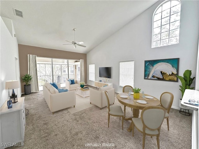 living room featuring high vaulted ceiling, light colored carpet, and ceiling fan