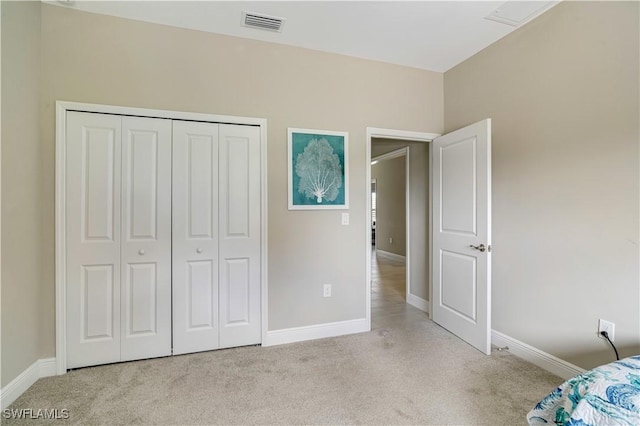 unfurnished bedroom with light carpet and a closet