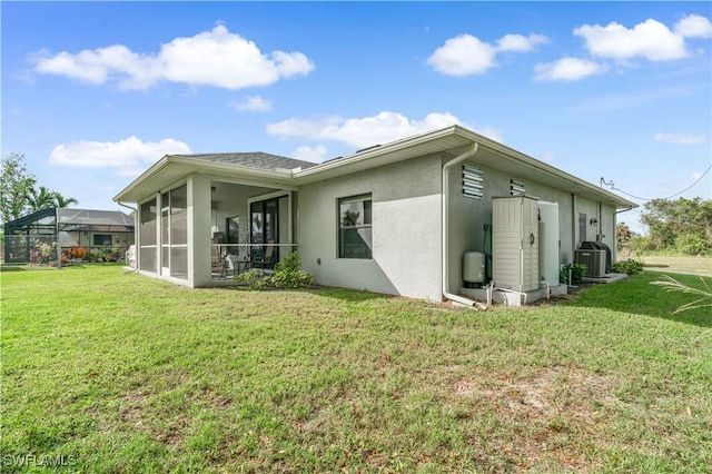 view of home's exterior featuring a yard, central AC unit, and a sunroom