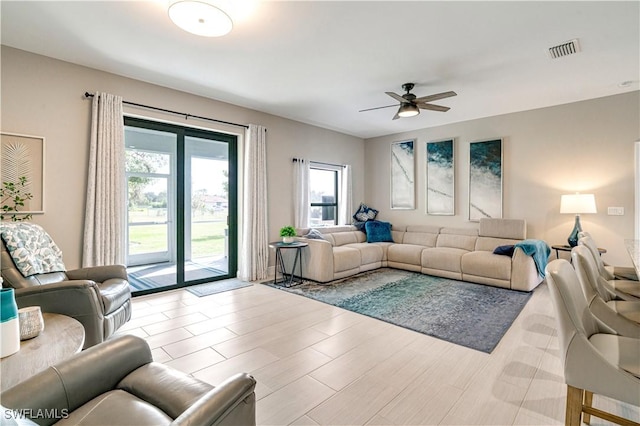 living room with light hardwood / wood-style floors and ceiling fan