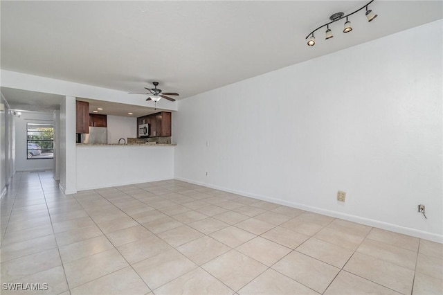 unfurnished living room featuring light tile patterned floors and ceiling fan