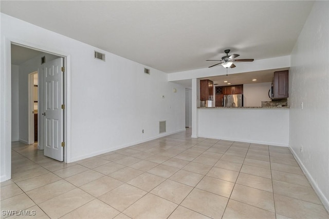 unfurnished living room featuring light tile patterned floors and ceiling fan