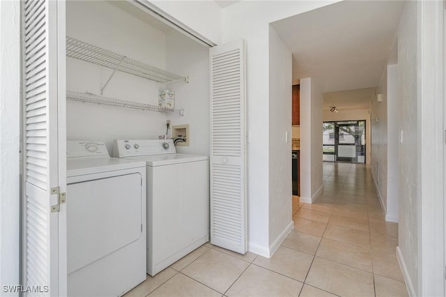 laundry area featuring light tile patterned floors and washer and dryer