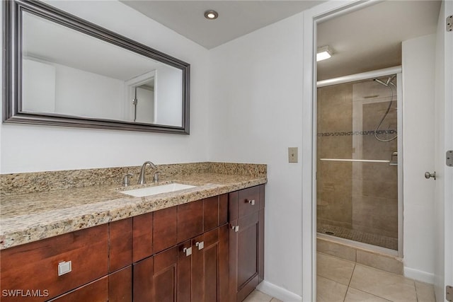 bathroom featuring vanity, a shower with shower door, and tile patterned floors