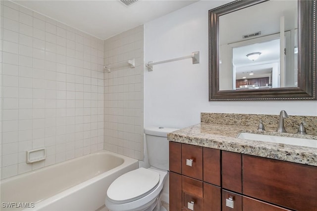 full bathroom featuring tiled shower / bath combo, vanity, and toilet