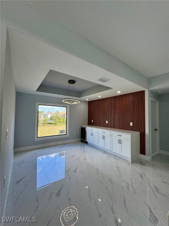 unfurnished living room with a tray ceiling