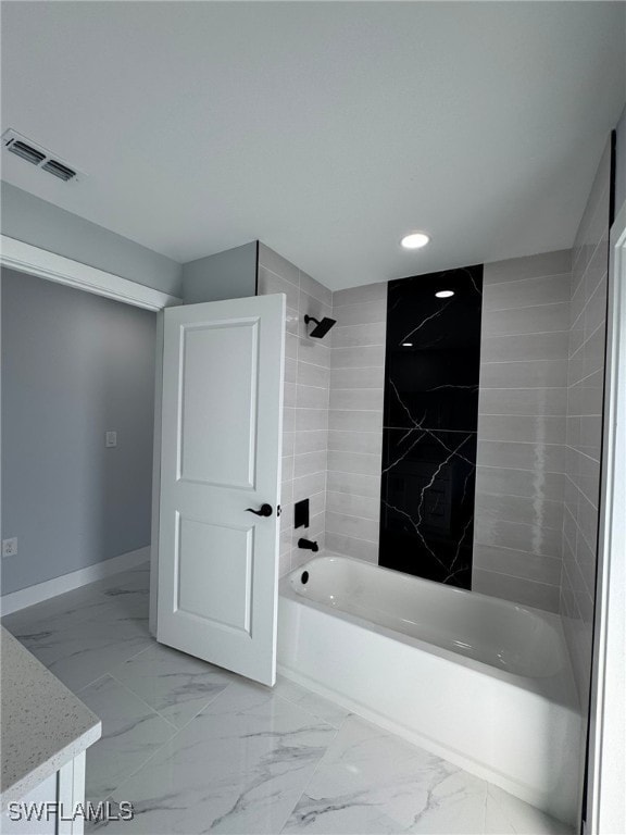 bathroom featuring tiled shower / bath and vanity