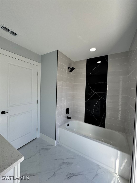 bathroom with vanity and tiled shower / bath combo