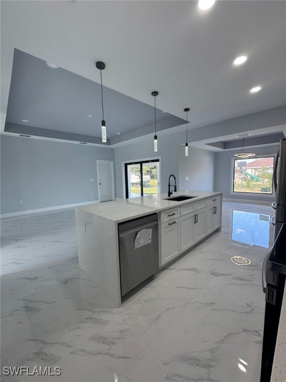 kitchen featuring sink, white cabinetry, hanging light fixtures, stainless steel dishwasher, and a kitchen island with sink