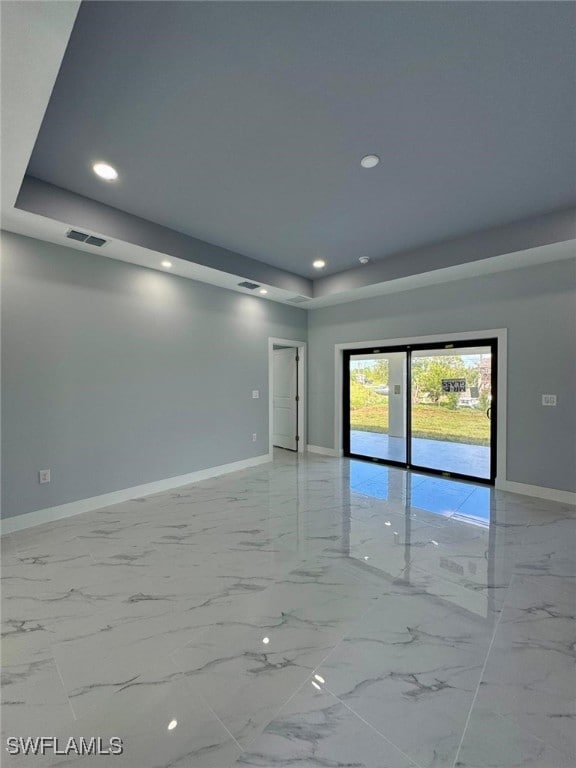 unfurnished room featuring a raised ceiling