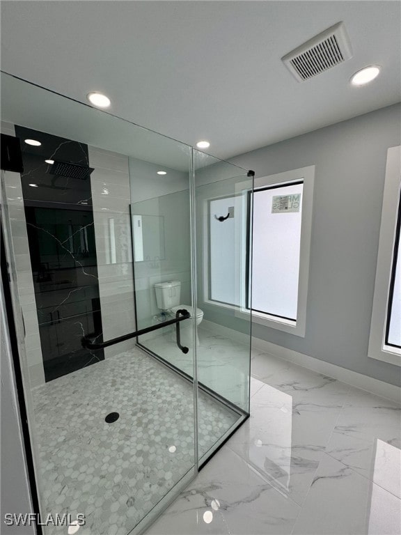 bathroom featuring toilet and a tile shower