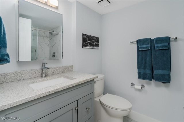 bathroom featuring vanity, toilet, and a shower with shower door