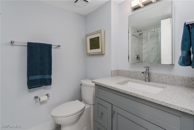 bathroom featuring walk in shower, vanity, and toilet