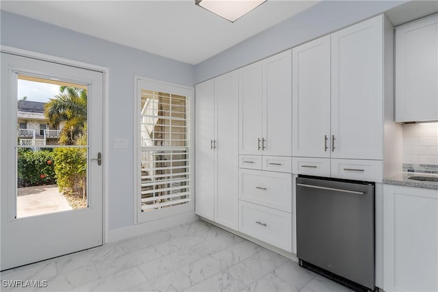 kitchen with white cabinetry, decorative backsplash, light stone countertops, and dishwasher