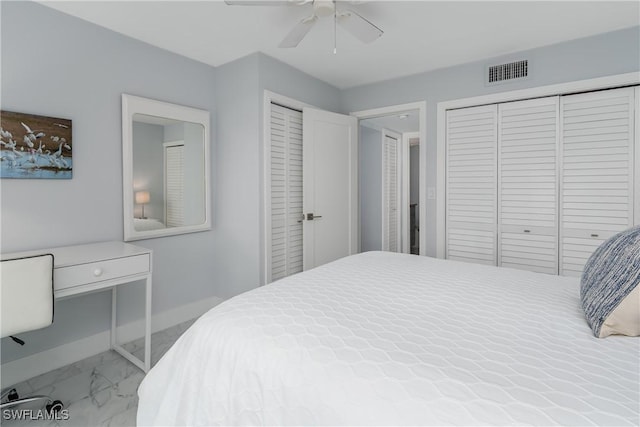 bedroom featuring ceiling fan and two closets