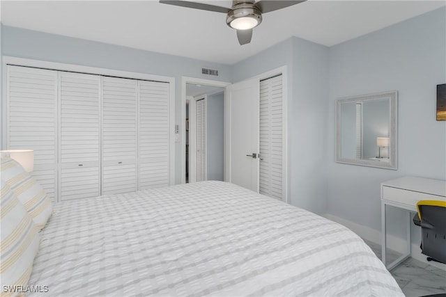 bedroom with ceiling fan and multiple closets