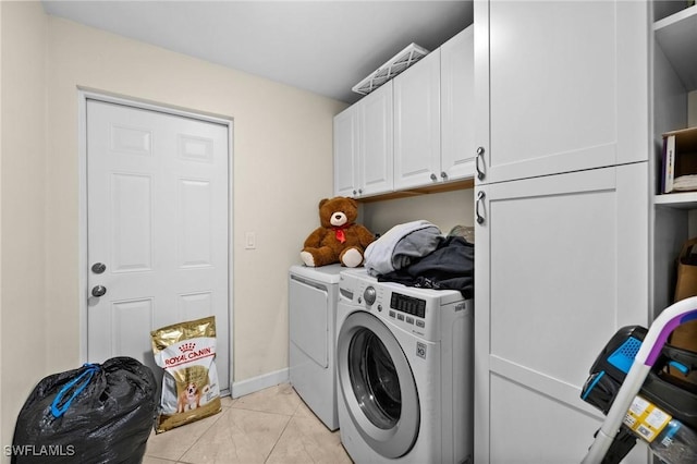 washroom with light tile patterned floors, independent washer and dryer, and cabinets