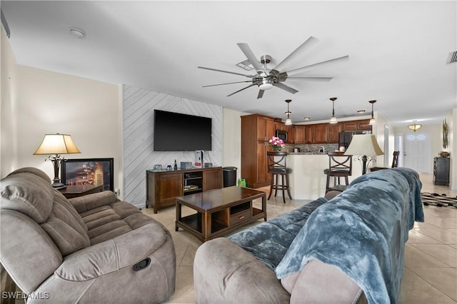 living room with wooden walls, light tile patterned flooring, and ceiling fan