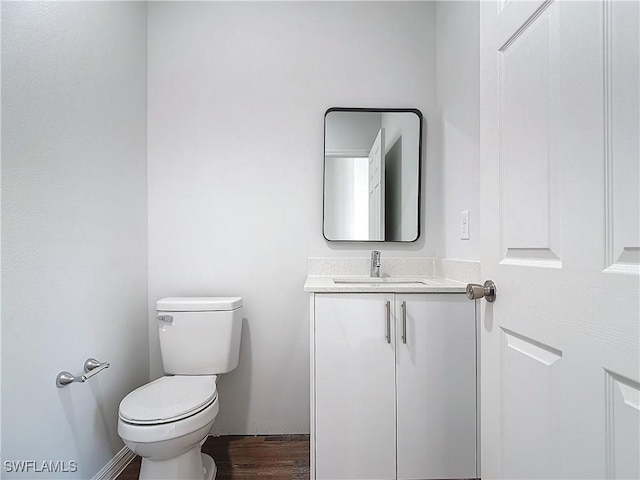 bathroom with vanity, wood-type flooring, and toilet