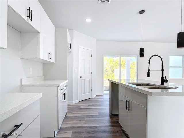 kitchen with plenty of natural light, decorative light fixtures, sink, and white cabinets