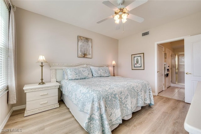 bedroom featuring light wood finished floors, a ceiling fan, visible vents, and baseboards