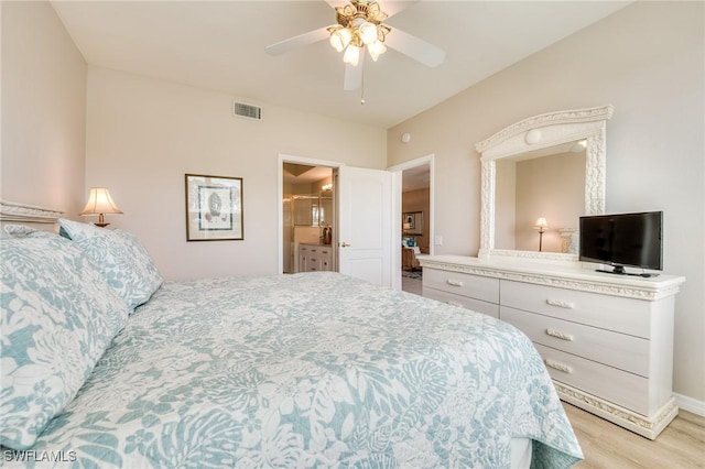 bedroom with light wood finished floors, ceiling fan, visible vents, and ensuite bathroom