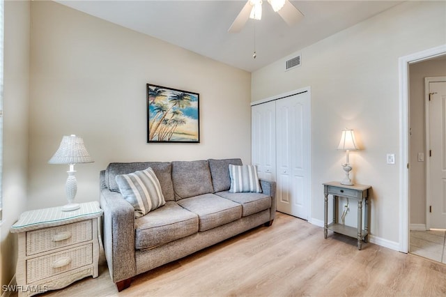 living room featuring light wood-style floors, visible vents, ceiling fan, and baseboards