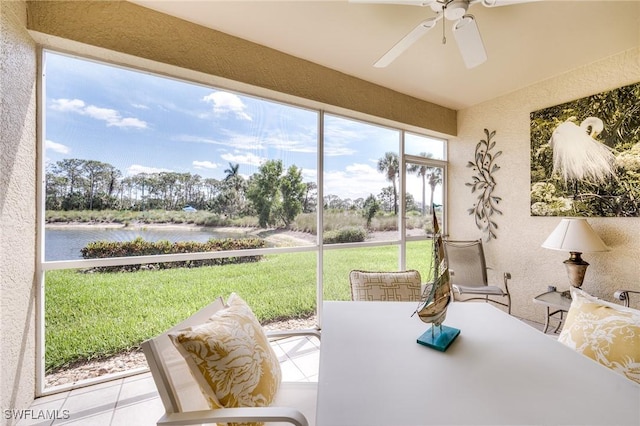 sunroom / solarium featuring a water view and a ceiling fan